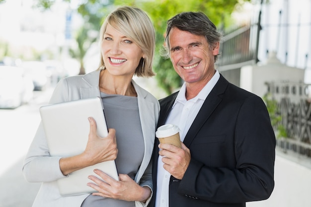 Portrait of business people with coffee and tablet