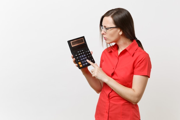 Portrait of business teacher or accountant woman in red shirt, glasses holding calculator in hands isolated on white background. Education teaching in high school university, accounting count concept.