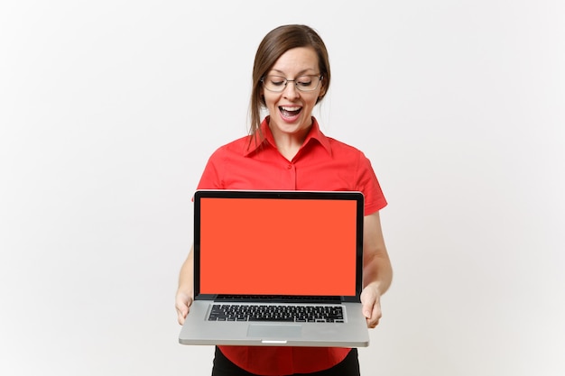 Portrait of business teacher woman in red shirt hold laptop pc computer with blank black empty screen to copy space isolated on white background. Education teaching in high school university concept.