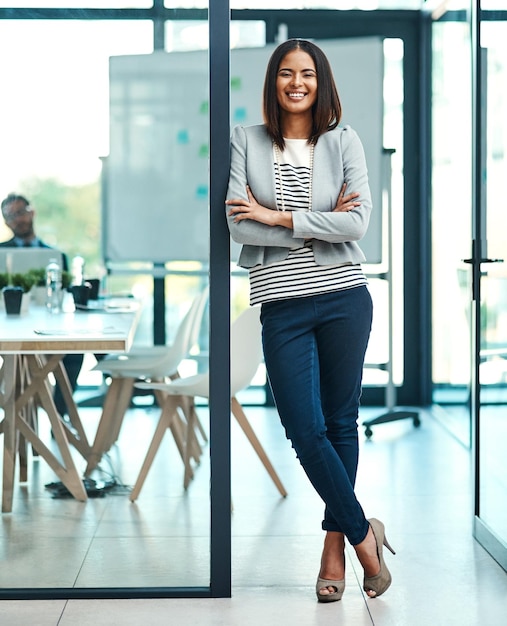 Portrait business and woman with arms crossed smile and startup success in a modern office Face female person and employee with confidence motivation and career with professional and leadership