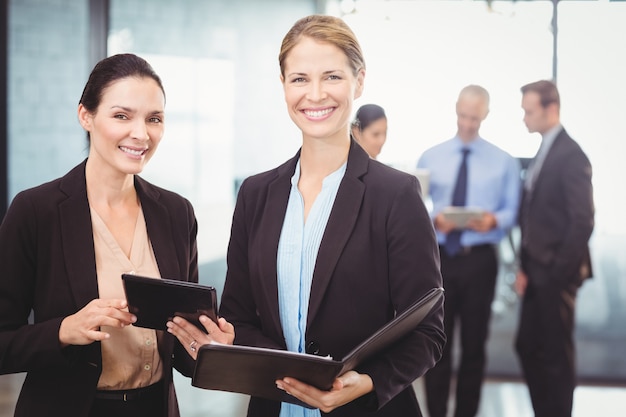 Portrait of business women holding digital tablet and file