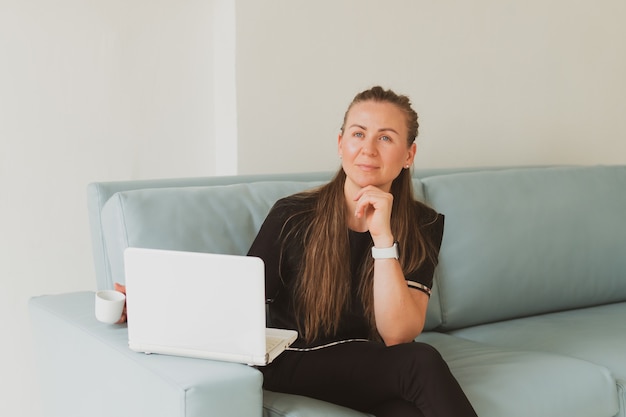 Portrait of business young woman with laptop sitting on sofa