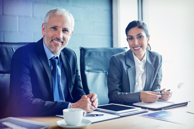 Photo portrait of businessman and businesswoman sitting in conference room