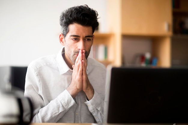 Portrait of businessman at desk looking at laptop