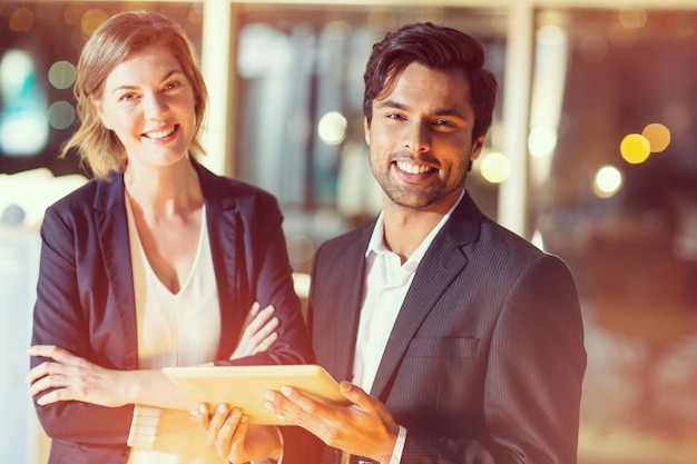 Portrait of businessman discussing with colleague over digital tablet