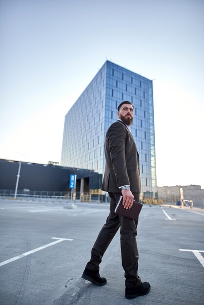 portrait of a businessman in front of corporate buildings