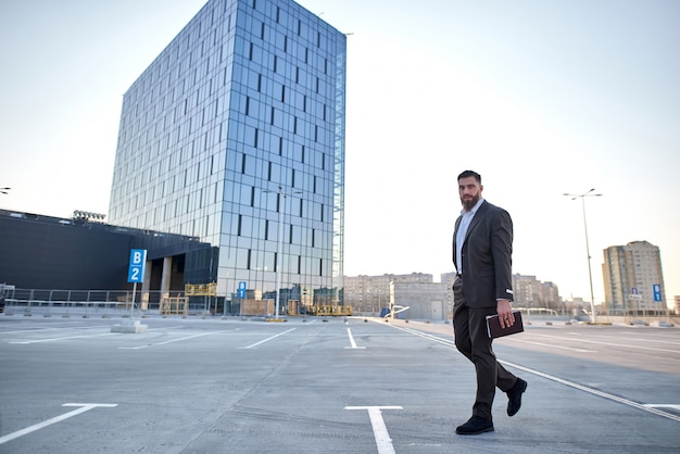 portrait of a businessman in front of corporate buildings