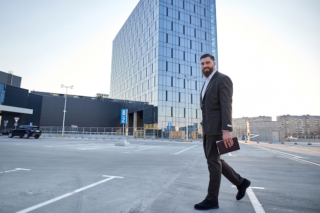 portrait of a businessman in front of corporate buildings