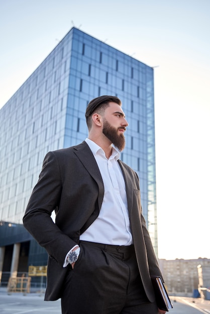 portrait of a businessman in front of corporate buildings