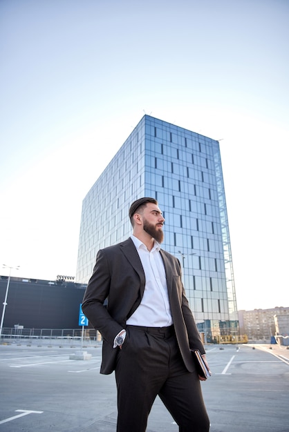 portrait of a businessman in front of corporate buildings