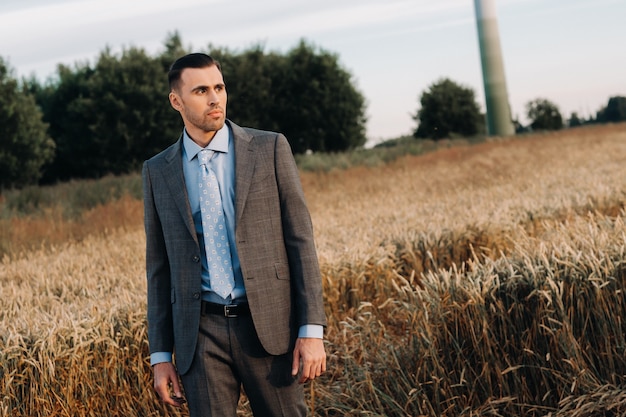 Portrait of a businessman in a gray suit in a wheat field.A man in nature in a jacket and tie