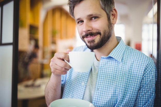 Portrait of businessman having coffee at office cafeteria