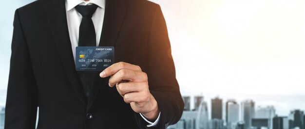 Portrait of a businessman holding a credit card.