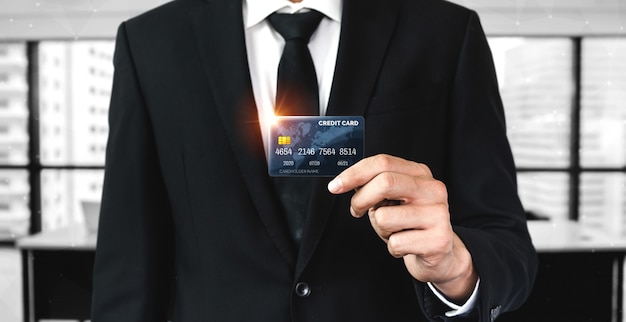 Portrait of a businessman holding a credit card.