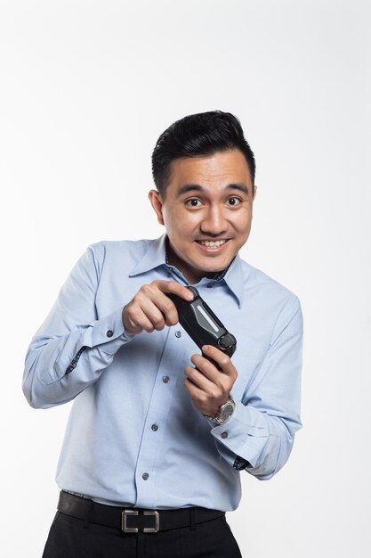 Photo portrait of businessman holding game controller while standing against white background