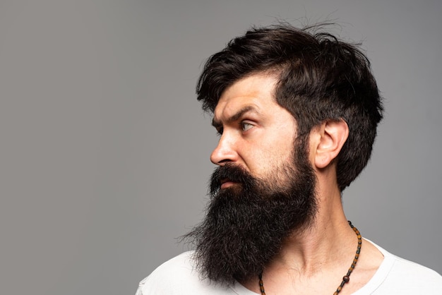 Portrait of businessman isolated on grey background. Bearded man thinking with expression looking. Handsome male model, closeup face.