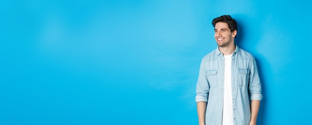 Portrait of businessman standing against blue background