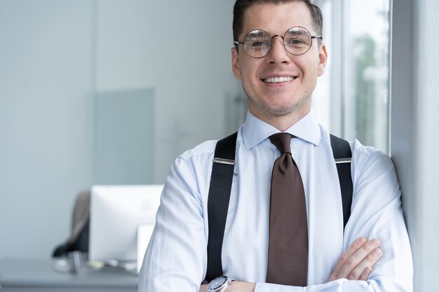 Portrait Of Businessman Standing By Window In Office.