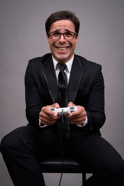 Portrait of businessman in suit playing games