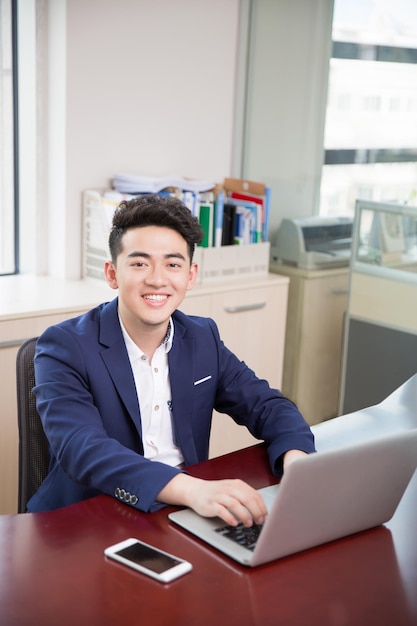 테이블에 앉아 노트북을 사용하는 사업가의 초상화