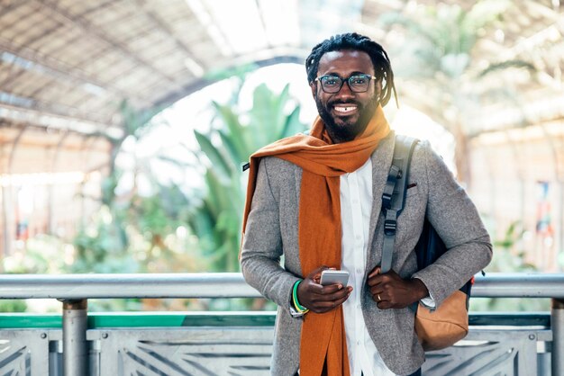 Portrait of businessman using phone while standing at airport