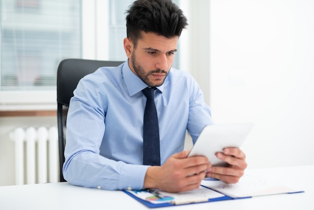 Portrait of a businessman using a tablet in his office