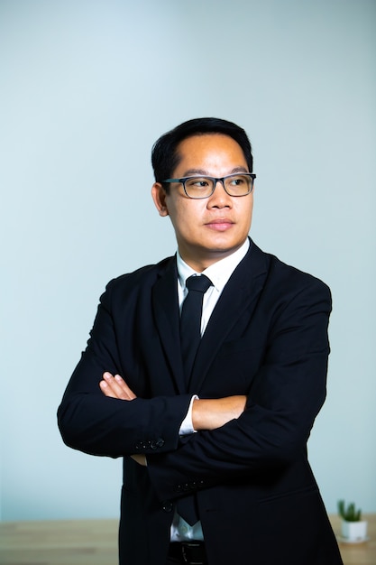 Portrait of businessman wearing glasses on grey background. Close up face of happy successful business man