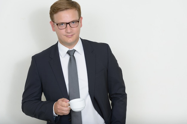 Portrait of businessman with blond hair holding coffee cup