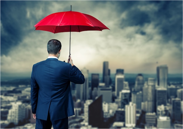 Portrait of  businessman with umbrella on background