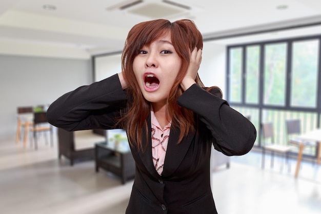 Portrait of businesswoman screaming while standing in office