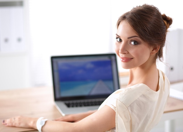 Portrait of a businesswoman sitting at desk with laptop