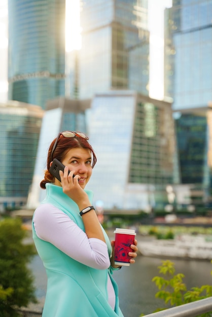 Portrait of a businesswoman talking on the phone with a cup of coffee