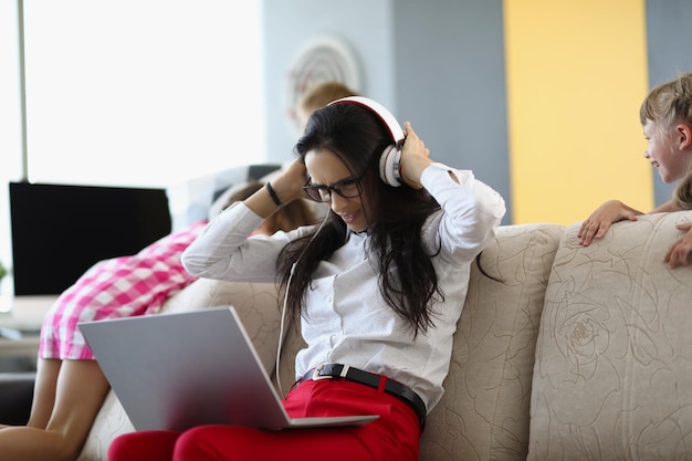 Portrait of businesswoman trying to work at home while kids playing and screaming female