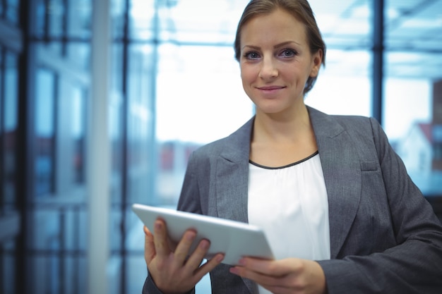 Portrait of businesswoman using digital tablet in corridor