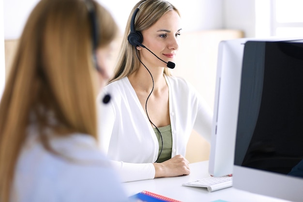 Portrait of call center operator at work. Group of people in a headset ready to help customers. Business concept.