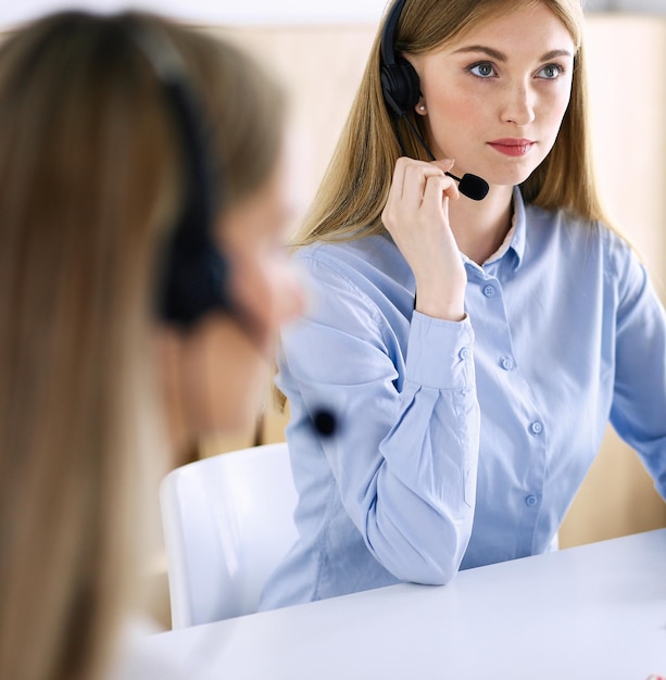 Portrait of call center operator at work. Group of people in a headset ready to help customers. Business concept.