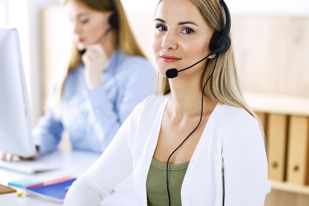 Portrait of call center operator at work. Group of people in a headset ready to help customers. Business concept.