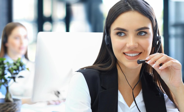 Portrait of call center worker accompanied by his team Smiling customer support operator at work