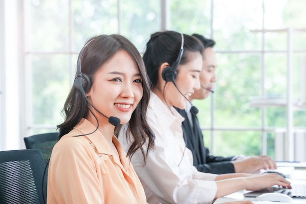 Photo portrait of call center worker accompanied by man and woman team. smiling customer support operator at work. concept people telephone operator. call center. customer support.