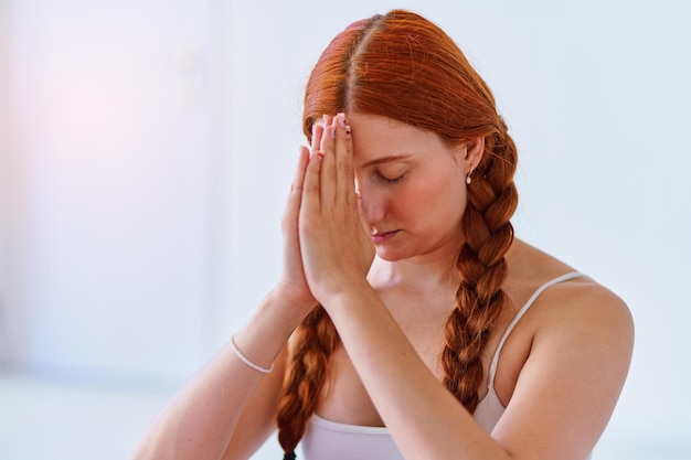 Photo portrait of calm breathing woman with closed eyes and hands namaste pose practices yoga exercise