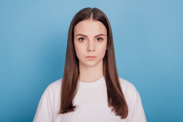 Portrait of calm serious dream teenager lady look camera on blue background
