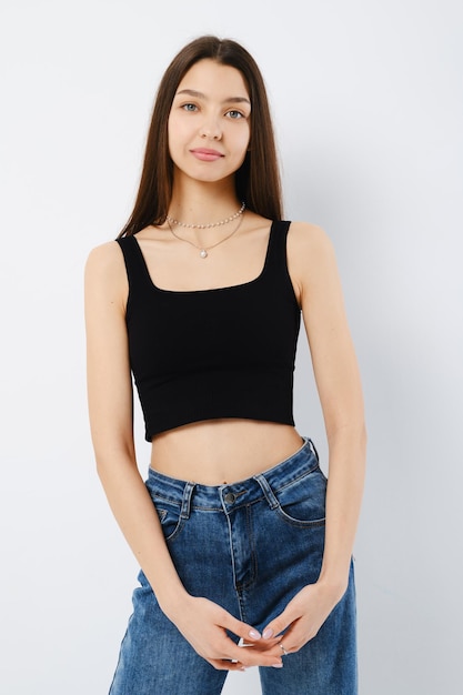 Portrait of calm young woman in black tank top and wide jeans