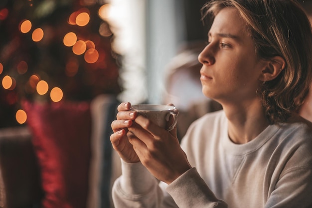 Portrait of candid authentic dreamer boy teenager in sadness depressing emotion at home Xmas