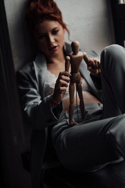 Portrait of candid authentic sexy redhead model girl posing in gray pantsuit with bra at studio