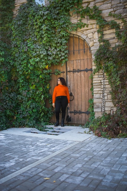 Portrait of carefree young woman smiling with big door background cheerful latin girl wearing eyegla