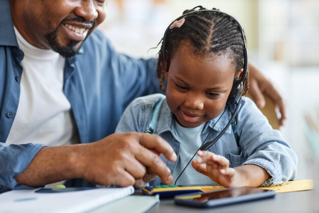 Портрет заботливого отца и ребенка, играющих с игрушечным калькулятором, которые учатся считать вместе