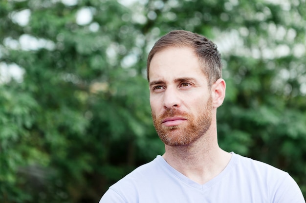 Portrait of a casual bearded man in a park