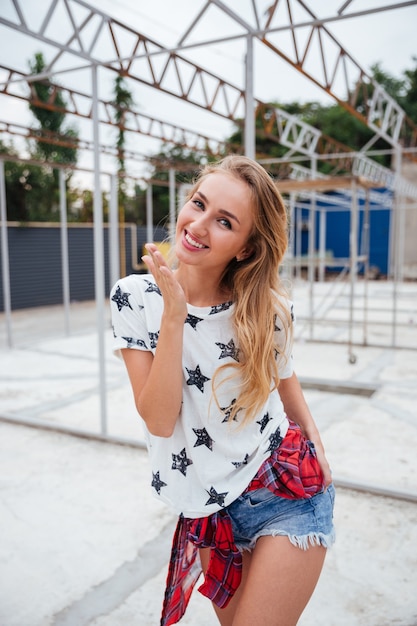 Portrait of a casual playful blonde woman standing outdoors