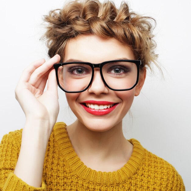 Portrait of a casual woman in glasses looking at camera isolated on a white background