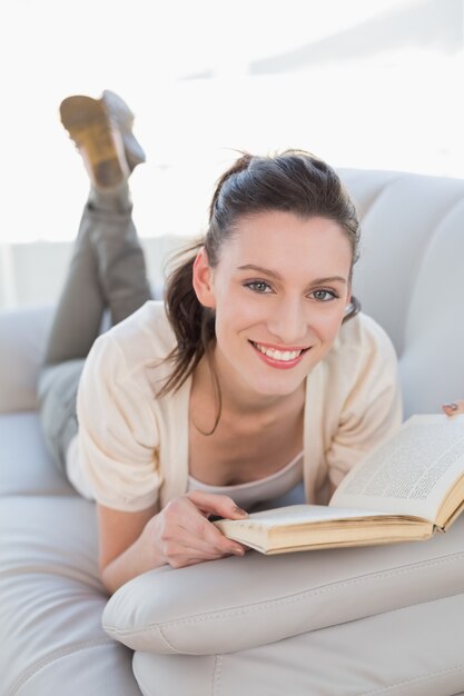 Portrait of a casual woman reading a book on sofa